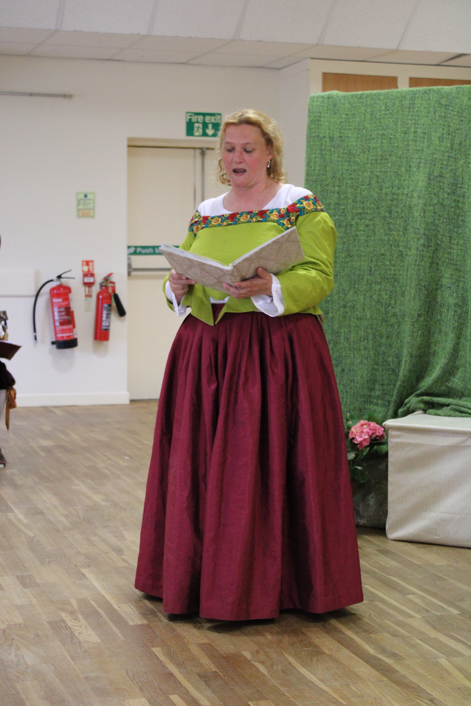 A woman reading aloud from a book