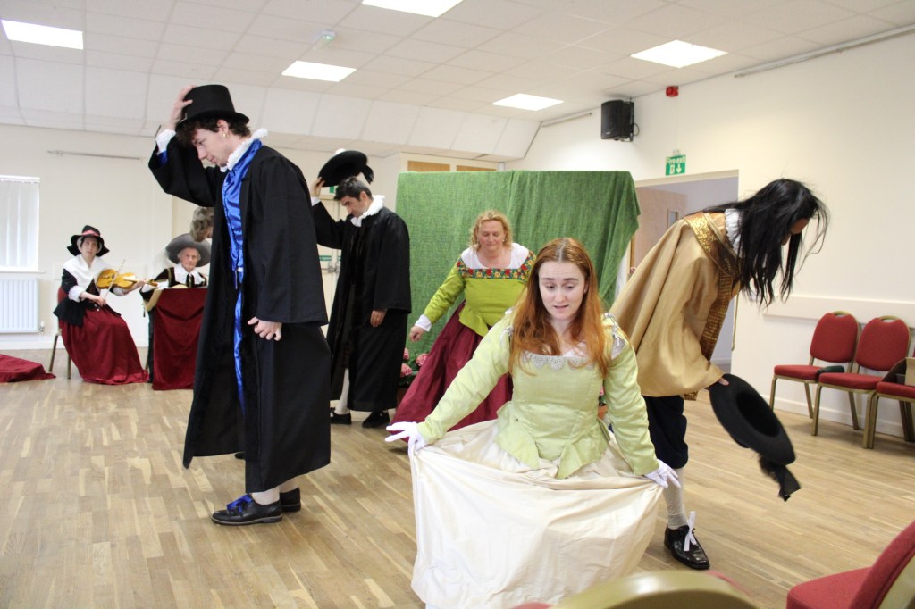 a group of people in costume bowing and curtseying