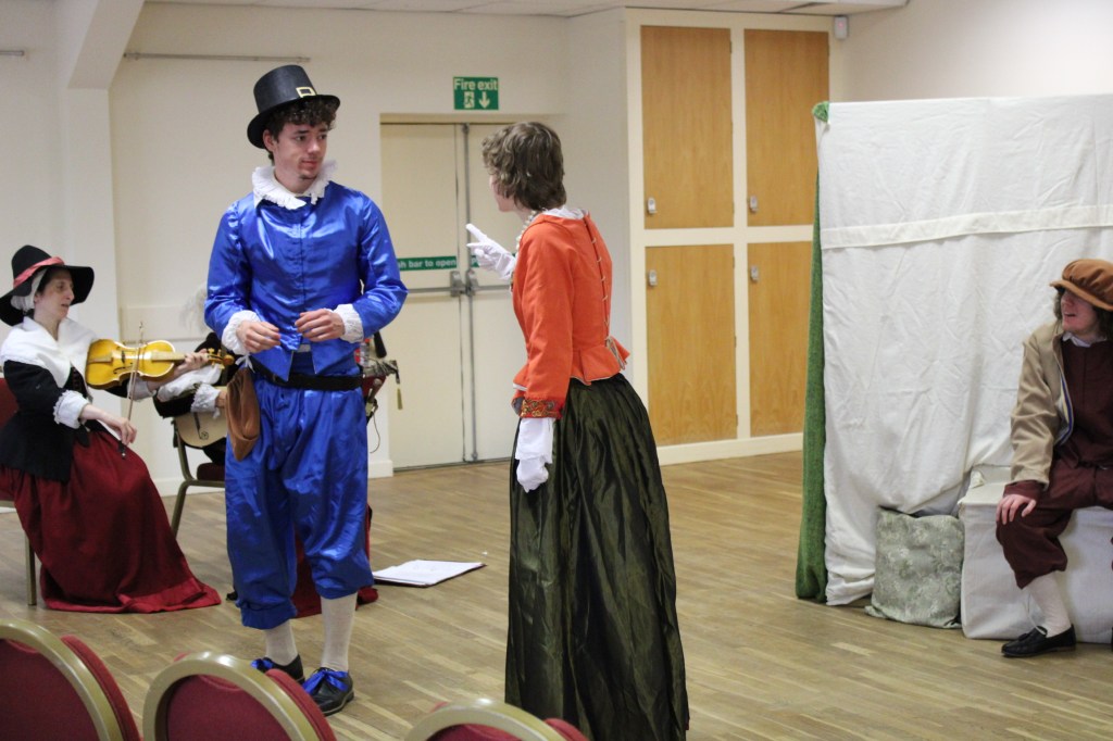 A woman pointing at a man who recoils in fear