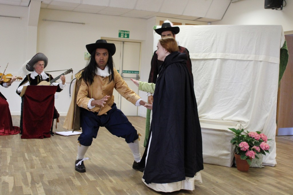 A group of people in early modern costume, one looking very surprised