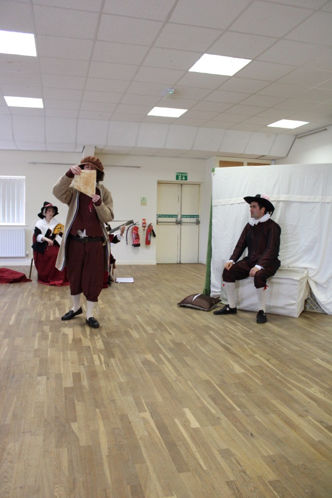 A man reads a letter to another man