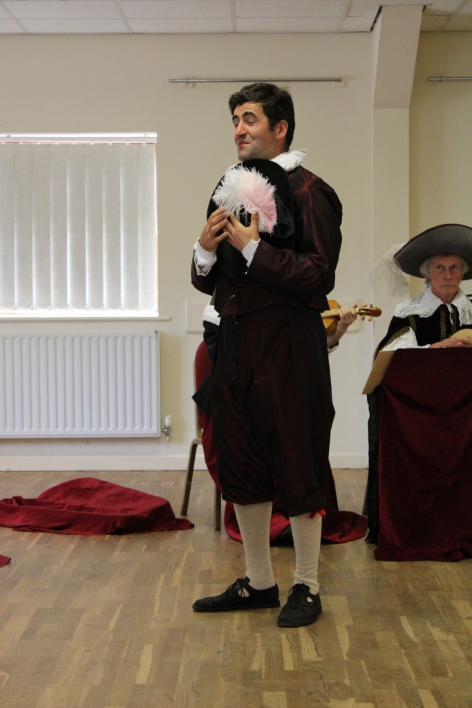 A man holding his hat to his chest