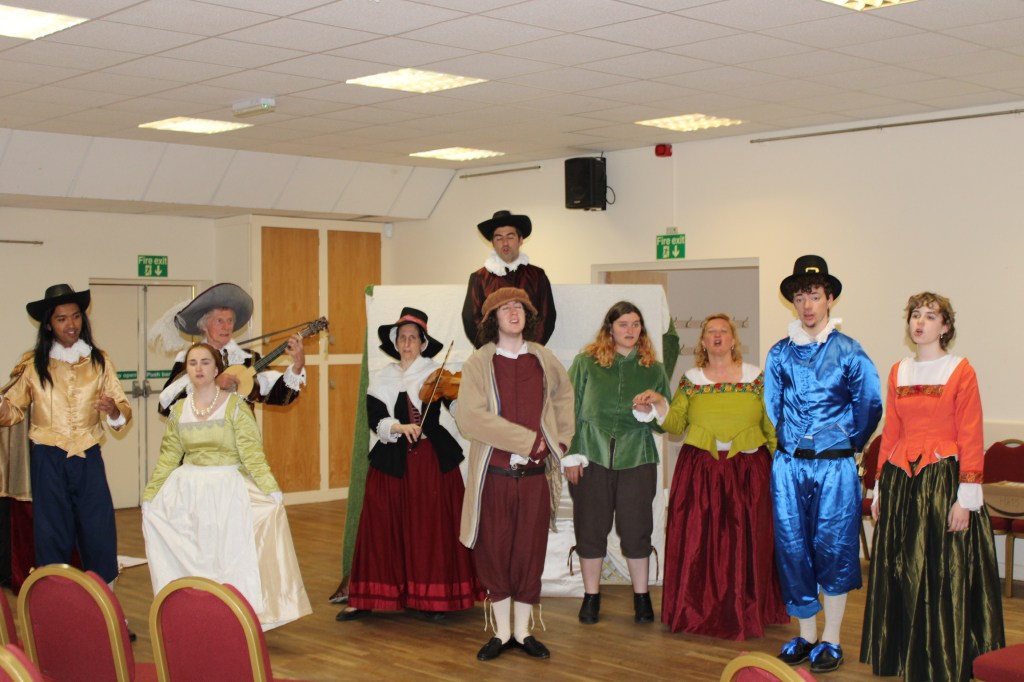 a group of people in early modern costume, singing